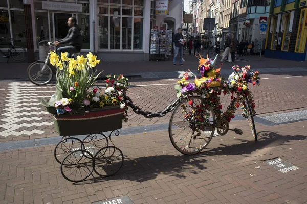 Велосипед с телегой, украшенный искусственными цветами и резиновой уткой, которая рекламирует сувенирный магазин . — стоковое фото