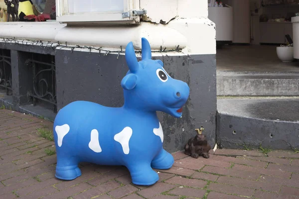 Caoutchouc bleu à taches blanches vache et grenouille avec une couronne dorée à l'entrée du magasin — Photo