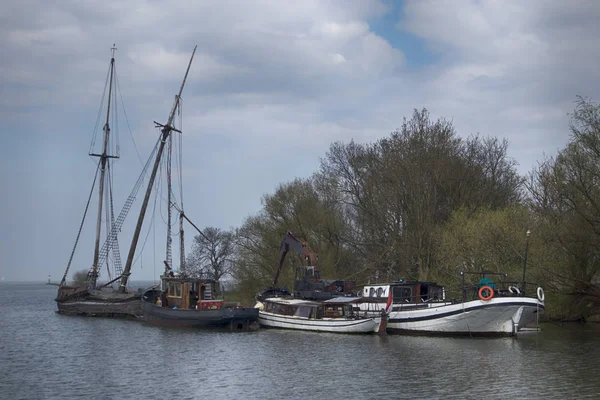 Port et le château Muiderslot dans le village hollandais. Vieux yacht abandonné brisé — Photo