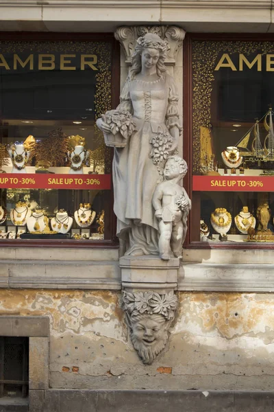 Showcase för den butik som säljer bärnsten är dekorerad med en staty av en kvinna med ett barn — Stockfoto