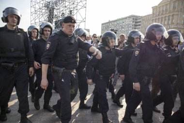 Bir muhalefet protesto mitingi öncesinde devlet başkanı Vladimir Putin'ın açılış töreni sırasında Puşkin Meydanı'nda polis memuru isyan dişli.