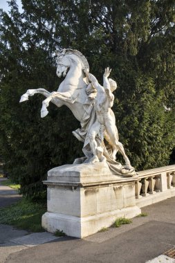 Güneşin doğuşunda atıyla birlikte müze binasına bakan bir adamın heykeli..