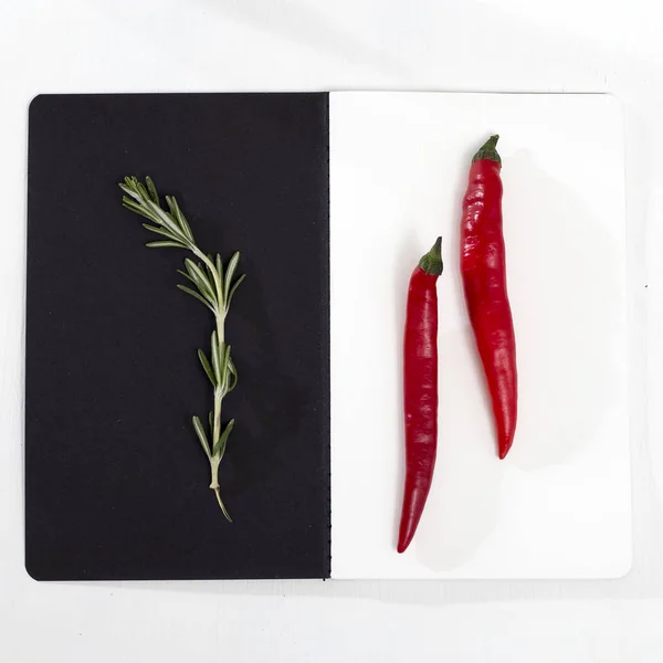 黑纸背景上的迷迭香枝条 白色的红辣椒 — 图库照片