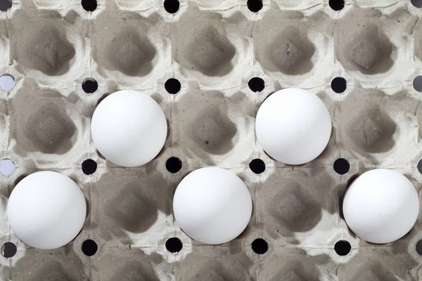 白い段ボール容器に鶏の卵はベージュの木製のキッチンテーブルの上に横たわる. — ストック写真