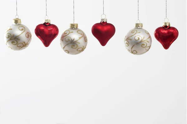 Gray Christmas balls with gold ornaments and red glass hearts hanging on the ropes. Greeting card. Empty space — Stock Photo, Image