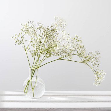 Bir rafta cam vazoda düğün buketi