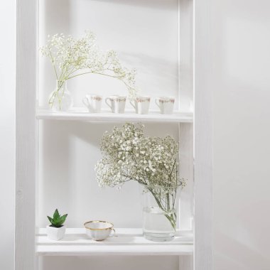 Bir rafta cam vazoda düğün buketi