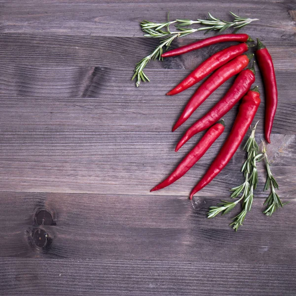 Rosemary and chili pepper, top view on the brown wooden background , web banner with copy space — Stock Photo, Image