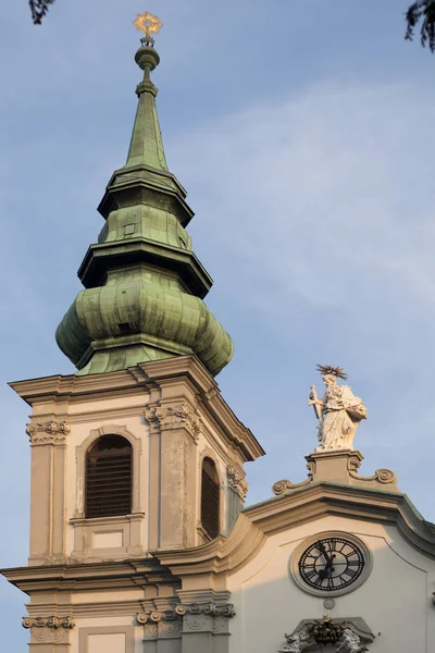 Toren van de Stiftskirche Kerk aan de Mariahilfer Strasse Straat in Wenen in Oostenrijk. Kathedraal archtectuur in Wien. Basiliek gebouw oriëntatiepunt. Blauwe lucht achtergrond — Stockfoto