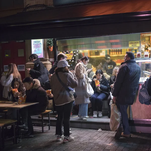 People buy Asian food at an outdoor cafe on Oxford Street. — Stock Photo, Image