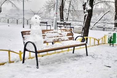 Salıncaklı oyun alanı ve banklarda kardan adamlar.