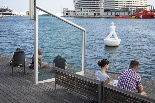 Los turistas descansan rodeados de gaviotas en el antiguo puerto de la ciudad de Barcelona . — Foto de Stock