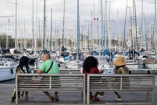 Turisterna vilar omgiven av måsar i den gamla hamnen i staden Barcelona. — Stockfoto