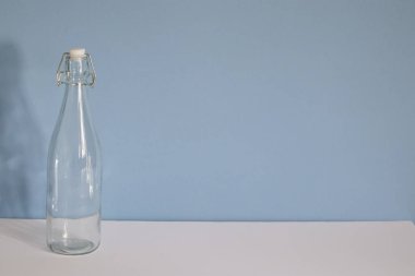 Mavi beyaz arka planda boş cam şişe.