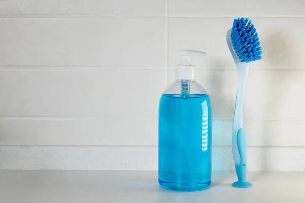 Jabón azul líquido con dispensador en una botella de plástico y un cepillo para limpiar cerámica —  Fotos de Stock
