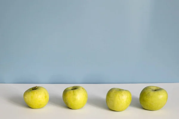Four apples on a blue white background