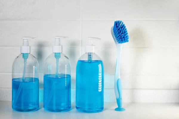 Jabón azul líquido con dispensador en una botella de plástico y un cepillo para limpiar cerámica —  Fotos de Stock