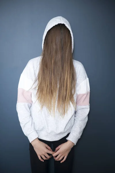 Νεαρή κοπέλα με κουκούλα, μαλλιά που φράζουν το πρόσωπό της, το πρόσωπό της δεν είναι — Φωτογραφία Αρχείου