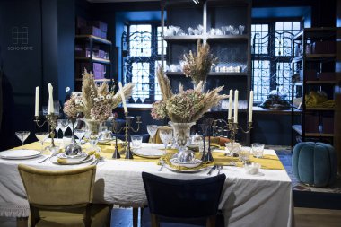 Regent Caddesi 'ndeki Liberty mağazasının içinde. Beyaz masa örtüsü olan büyük bir masa, büyük vazolarda ortanca çiçekleriyle porselenlerle servis edilir..