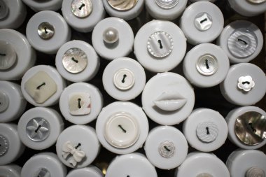 Bir mağazada satılık ahşap kutularda çok renkli düğmeler.