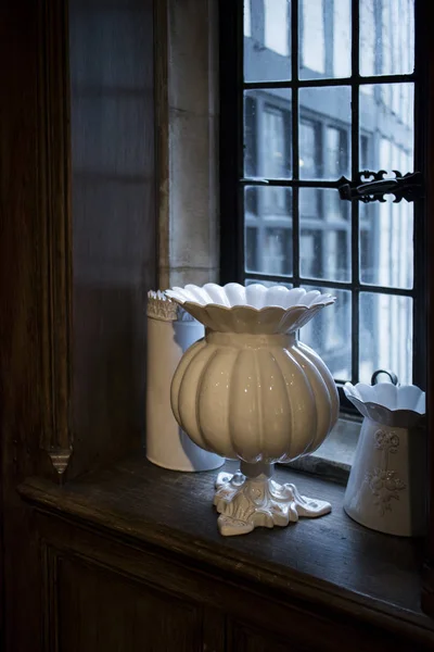 Grand vase en porcelaine blanche se dresse sur un rebord de fenêtre en bois d'une vieille maison anglaise — Photo