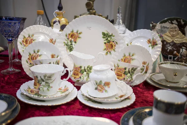 The multicolored tea and dining sets at a flea market for sale — Stock Photo, Image