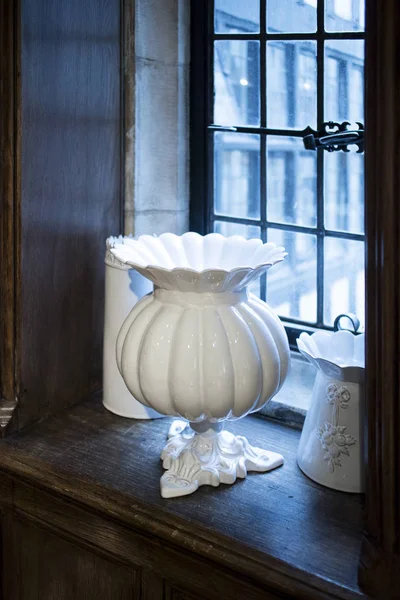 Gran jarrón de porcelana blanca se encuentra en un alféizar de ventana de madera de una antigua casa Inglés — Foto de Stock