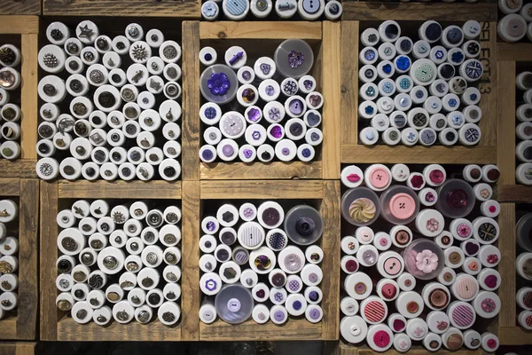 Flerfärgade knappar i trälådor till salu i butik. — Stockfoto