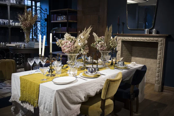 摄政街的自由商店的内部。 一个有白色桌布的大桌子与瓷器一起上桌，大花瓶里放满了水仙花. — 图库照片
