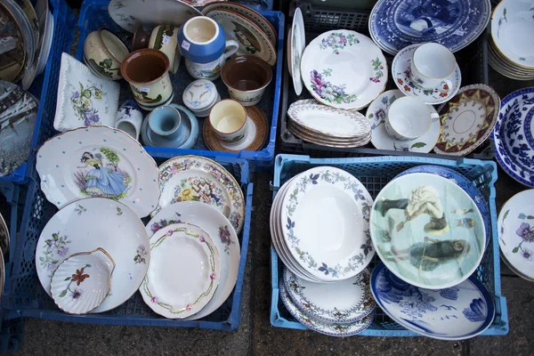 Os conjuntos de chá e jantar multicoloridos em um mercado de pulgas para venda — Fotografia de Stock