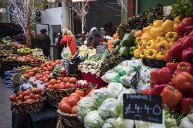 Borough Market 'in tezgahında farklı sebze ve salatalar var. Bir sebze dükkanının içinde.