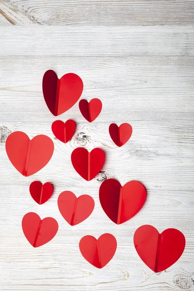 Corazones de plástico rojo sobre una mesa de madera gris . —  Fotos de Stock