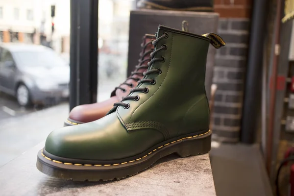 Couro clássico verde e borgonha Dr. sapatos Martens com cadarços amarelos para venda em uma vitrine — Fotografia de Stock