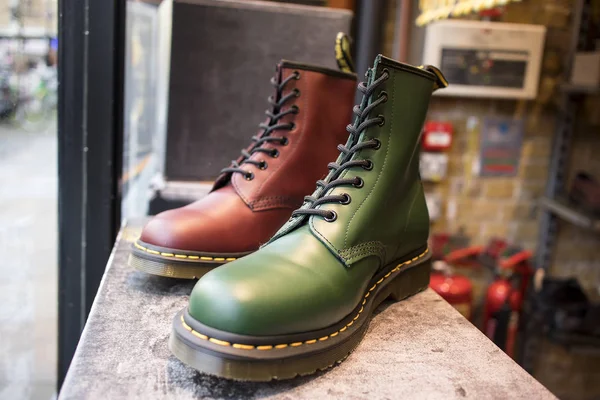 Classic green and burgundy leather Dr. shoes Martens with yellow shoelaces for sale in a shop window — Stock Photo, Image
