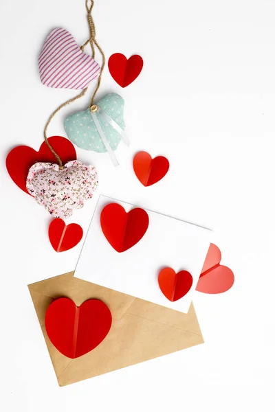 Greeting card for Valentine's Day. Envelopes on a white background and red plastic hearts. — 스톡 사진