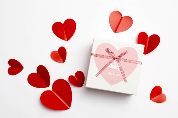 Tarjeta de felicitación para el día de San Valentín. Sobres sobre fondo blanco y corazones rojos de plástico . — Foto de Stock