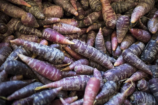 Wortelen: paars, geel en oranje te koop op een toonbank in de Borough Market — Stockfoto