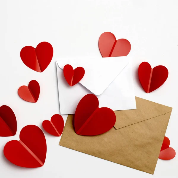 バレンタインデーのグリーティングカード。白い背景と赤いプラスチック製のハートのエンベロープ. — ストック写真