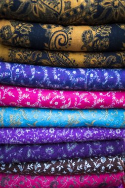 Folded cashmere stoles for sale in market.