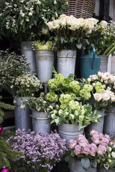 Bouquets of pink roses and red tulips, green hydrangea in pastel colors in large zinc buckets for sale in store. — 图库照片