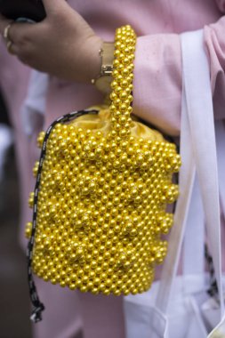 Küçük sarı boncuklu pembe takım elbiseli bir kız. Mevsimin vurgunu, yaz için süper havalı bir şey.