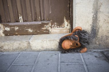 Maymun maskesi karnavaldan sonra duvara dayanıyor..