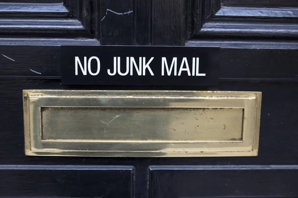 House letterbox with \'No junk mail\' sign and junk mail