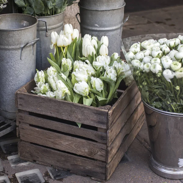 正方形のフォーマット ロンドンの自由の店の近くの色の様々な 錫の花瓶に大きな花束 木の箱の中のランヌクルスとチューリップ — ストック写真