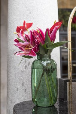 Covent Garden 'da bir restoran tezgahında uzun yeşil bir vazoda zambaklar ve zambaklar.