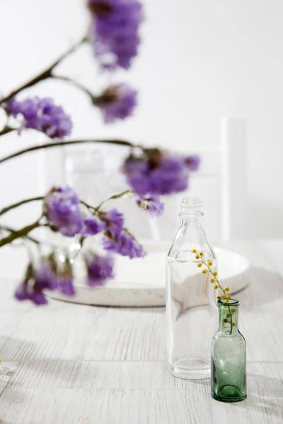 A small variety of pharmacy bottles instead of a vase for dried flowers.