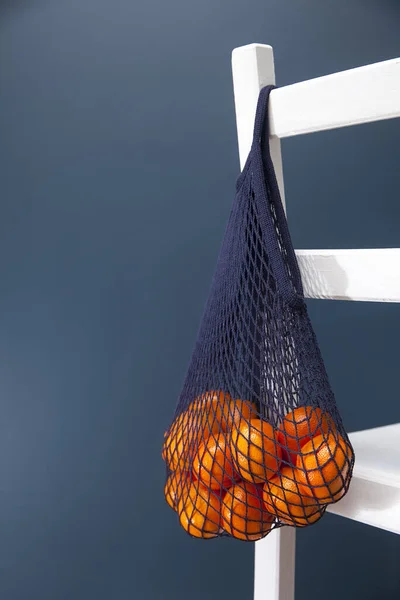 Eine Blaue Saitentasche Mit Mandarinen Hängt Der Lehne Eines Stuhls — Stockfoto