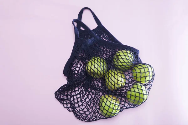 Blaue String Tasche Mit Grünem Apfel Auf Rosa Hintergrund — Stockfoto