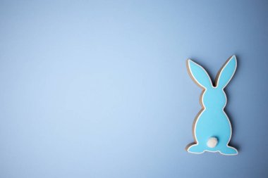 Mavi ahşap düz paskalya tavşanı mavi arka planda yatıyor. Boşluğu kopyala