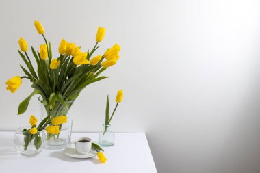 Sarı lale buketi beyaz duvarın karşısındaki masada. Boşluğu kopyala